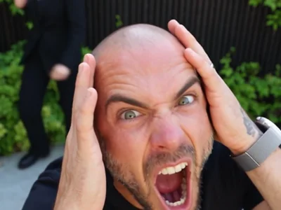 Reference performer holding their head in the opening close-up